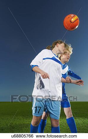 Female footballers heading the ball View Large Photo Image Stock Photograph - Female footballers heading the ball. Fotosearch