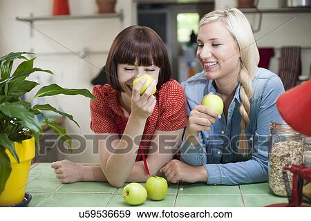 Female friends in kitchen with apples View Large Photo Image Stock Photo - Female friends in kitchen with apples. Fotosearch