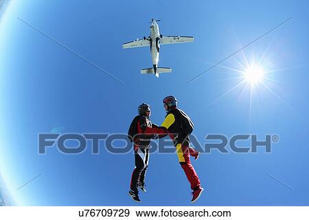Stock Photo - Female skydivers free falling above Leutkirch, Bavaria, Germany. Fotosearch