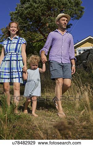 Female toddler and parents holding hands, Utvalnas, Gavle, Sweden View Large Photo Image Stock Photo - Female toddler and parents holding hands, Utvalnas, Gavle, Sweden. Fotosearch