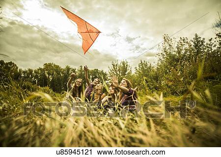 Five young women having fun with kite in scrubland View Large Photo Image Stock Image - Five young women having fun with kite in scrubland. Fotosearch