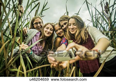 Five young women taking self portrait in marshes View Large Photo Image Stock Photo - Five young women taking self portrait in marshes. Fotosearch