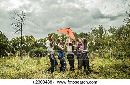 Five young women with kite in scrubland View Large Photo Image Stock Photo - Five young women with kite in scrubland. Fotosearch