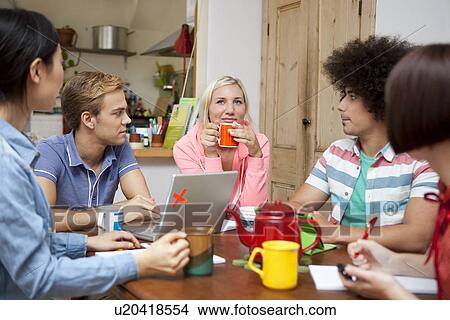 Flatmates planning around kitchen table View Large Photo Image Picture - Flatmates planning around kitchen table. Fotosearch