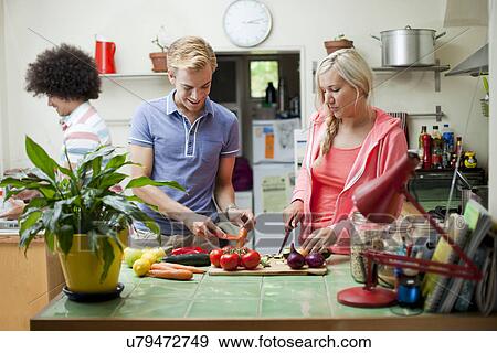 Flatmates preparing vegetables in kitchen View Large Photo Image Stock Photo - Flatmates preparing vegetables in kitchen. Fotosearch
