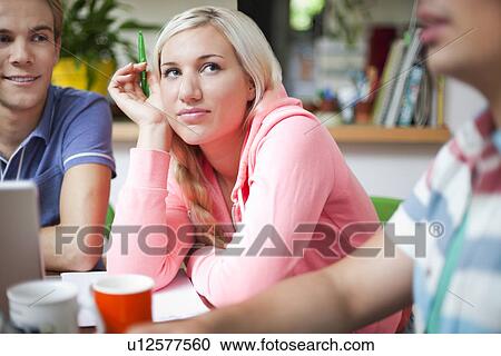 Stock Image - Flatmates sharing ideas around kitchen table. Fotosearch