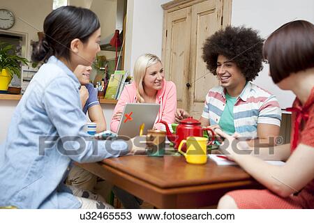 Flatmates sharing plans around kitchen table View Large Photo Image Stock Image - Flatmates sharing plans around kitchen table. Fotosearch