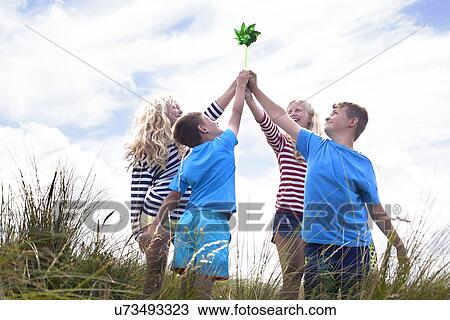 Four friends holding pinwheel, Wales, UK View Large Photo Image Stock Image - Four friends holding pinwheel, Wales, UK. Fotosearch