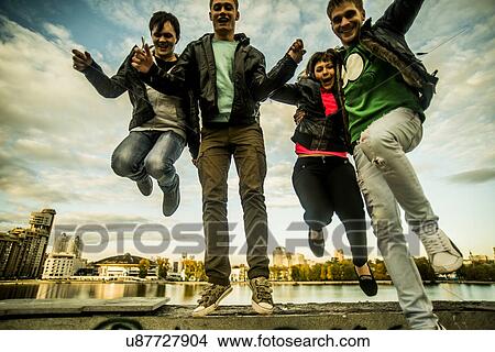 Four friends jumping mid air, Russia View Large Photo Image Picture - Four friends jumping mid air, Russia. Fotosearch