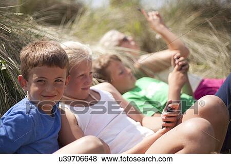 Four friends relaxing in dunes, Wales, UK View Large Photo Image Stock Photo - Four friends relaxing in dunes, Wales, UK. Fotosearch