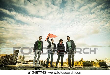 Four friends with one man holding kite, Russia View Large Photo Image Stock Image - Four friends with one man holding kite, Russia. Fotosearch