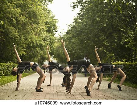 Stock Photo - Four young ballet dancers exercising in park. Fotosearch
