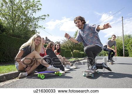 Four young women sitting on kerb watching skateboarders View Large Photo Image Stock Image - Four young women sitting on kerb watching skateboarders. Fotosearch