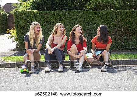 Four young women sitting on kerb with skateboards View Large Photo Image Stock Photo - Four young women sitting on kerb with skateboards. Fotosearch