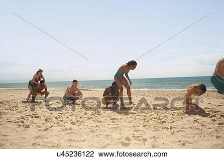 Stock Image - Friends having fun on beach. Fotosearch