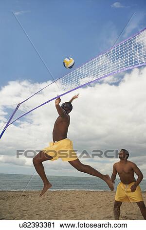 Friends playing volleyball on beach View Large Photo Image Stock Image - Friends playing volleyball on beach. Fotosearch