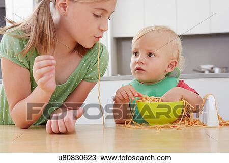 Girl and toddler playing with spaghetti View Large Photo Image Stock Image - Girl and toddler playing with spaghetti. Fotosearch