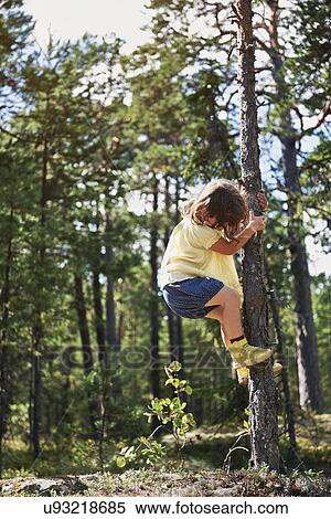 Stock Photography - Girl climbing tree. Fotosearch
