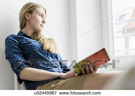 Girl looking up from book View Large Photo Image Stock Photo - Girl looking up from book. Fotosearch