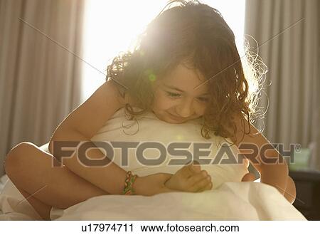 Girl on bed holding foot View Large Photo Image Stock Image - Girl on bed holding foot. Fotosearch