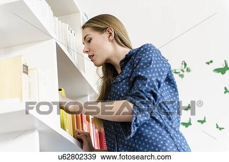 Stock Photo - Girl searching for book. Fotosearch