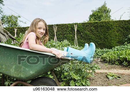 Girl sitting in wheelbarrow View Large Photo Image Stock Photo - Girl sitting in wheelbarrow. Fotosearch