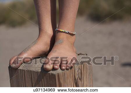 Girl standing on wooden groyne, Wales, UK View Large Photo Image Stock Photo - Girl standing on wooden groyne, Wales, UK. Fotosearch