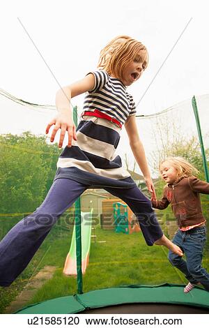 Stock Image - Girls jumping on trampoline. Fotosearch