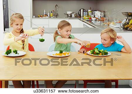 Girls scooping vegetables onto boy's plate View Large Photo Image Stock Photo - Girls scooping vegetables onto boy's plate. Fotosearch