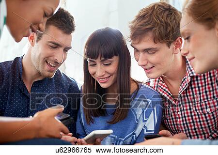 Stock Photography - Group of five friends using smartphones. Fotosearch