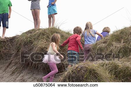 Group of friends on dunes, Wales, UK View Large Photo Image Picture - Group of friends on dunes, Wales, UK. Fotosearch