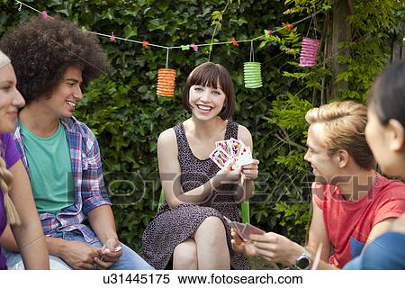 Group of friends playing cards in garden View Large Photo Image Stock Photography - Group of friends playing cards in garden. Fotosearch