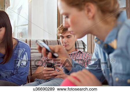 Group of friends using smartphones View Large Photo Image Stock Photo - Group of friends using smartphones. Fotosearch