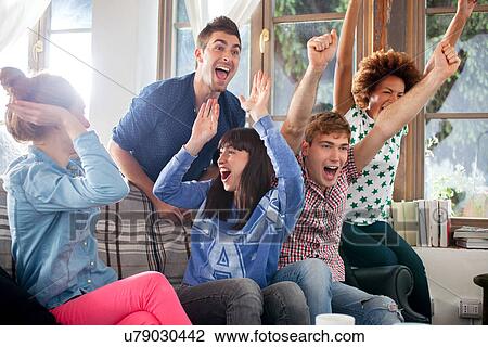 Group of friends watching tv cheering View Large Photo Image Stock Image - Group of friends watching tv cheering. Fotosearch