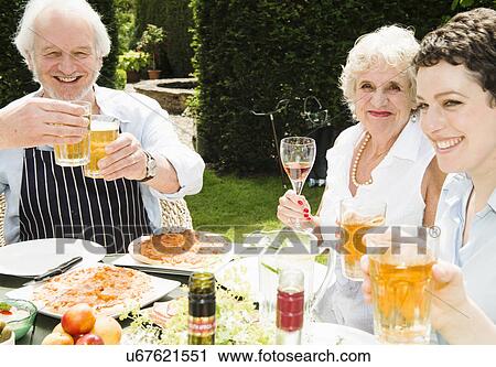 Group of people enjoying food and drink outdoors View Large Photo Image Stock Image - Group of people enjoying food and drink outdoors. Fotosearch