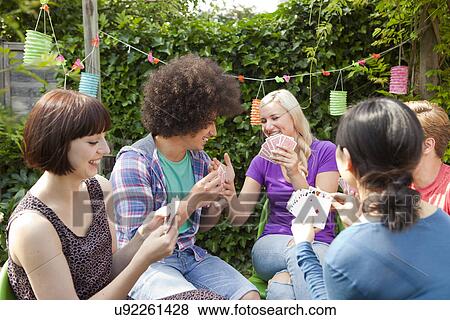 Group of young adult friends playing cards in garden View Large Photo Image Stock Photo - Group of young adult friends playing cards in garden. Fotosearch