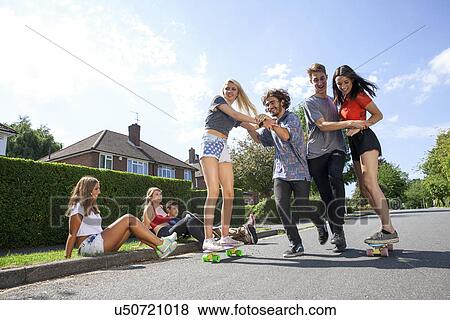 Group of young adults having fun on skateboards View Large Photo Image Stock Photo - Group of young adults having fun on skateboards. Fotosearch