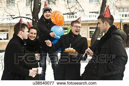Group of young friends on city street with birthday cake View Large Photo Image Stock Photo - Group of young friends on city street with birthday cake. Fotosearch