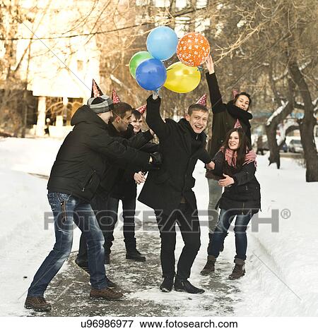 Group of young friends with party hats and balloons View Large Photo Image Stock Photo - Group of young friends with party hats and balloons. Fotosearch