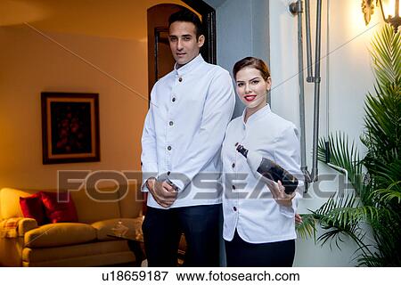 Stock Photo - Hotel staff at entrance with bottle of champagne. Fotosearch