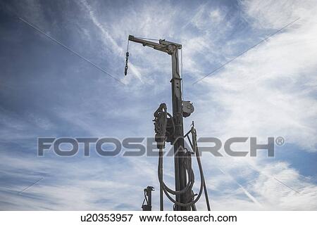 Stock Photo - Low angle view of drilling rig against blue sky. Fotosearch