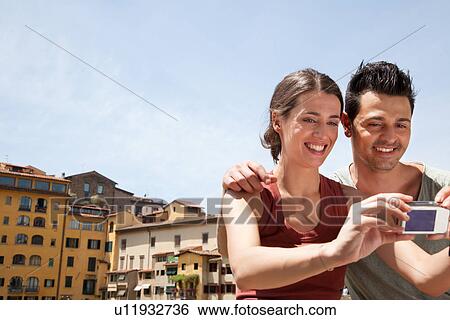 Man and woman photographing themselves on Ponte Vecchio, Florence, Tuscany, Italy View Large Photo Image Stock Photograph - Man and woman photographing themselves on Ponte Vecchio, Florence, Tuscany, Italy. Fotosearch