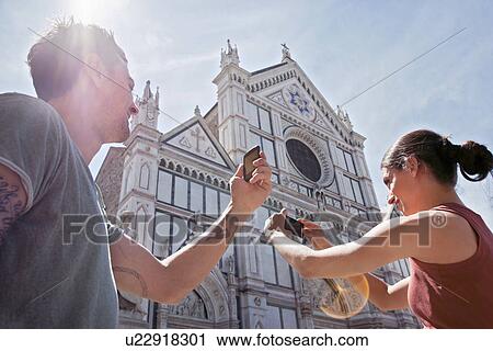 Stock Image - Man and woman photogrpahing Church of Santa Croce, Piazza di Santa Croce, Florence, Tuscany, Italy. Fotosearch