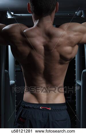 Stock Image - Man doing chin-ups. Fotosearch