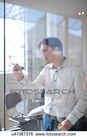 Man drawing architectural plans on glass wall View Large Photo Image Stock Photograph - Man drawing architectural plans on glass wall. Fotosearch