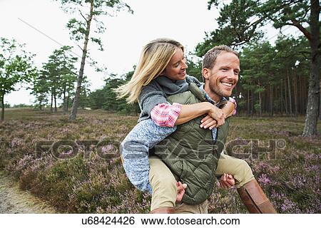 Man giving woman piggy back View Large Photo Image Stock Photograph - Man giving woman piggy back. Fotosearch