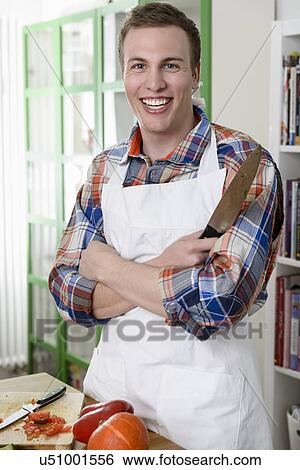 Stock Photograph - Man in apron posing for camera. Fotosearch