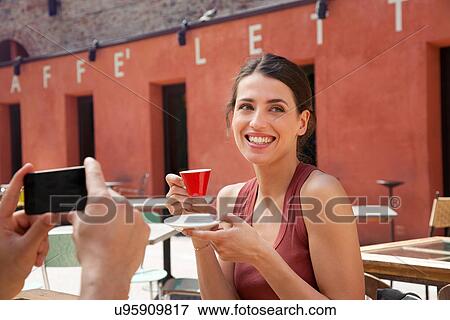 Stock Photo - Man photographing woman outside cafe, Florence, Tuscany, Italy. Fotosearch