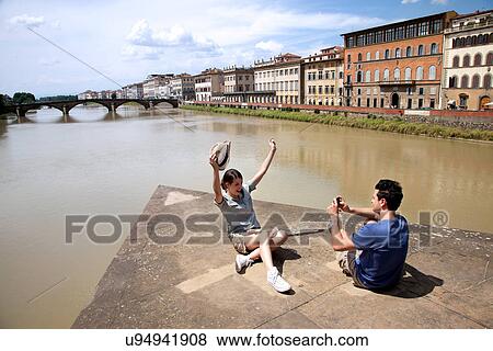 Man photographing woman with Ponte alle Grazie in background, Florence, Tuscany, Italy View Large Photo Image Stock Photo - Man photographing woman with Ponte alle Grazie in background, Florence, Tuscany, Italy. Fotosearch