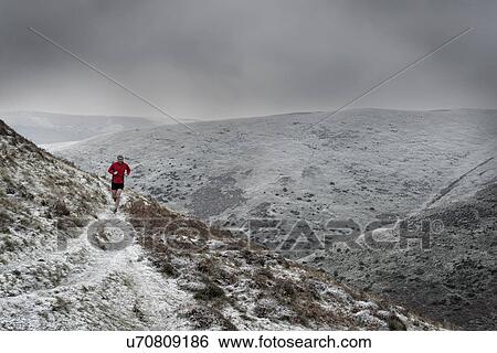 Stock Photograph - Man running on hill path, Church Stretton, Shropshire, England, UK. Fotosearch
